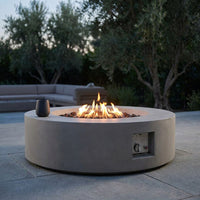 Brookhurst 43 In. W X 13 In. H round Outdoor GFRC Liquid Propane Fire Pit Table in Flint with Lava Rocks — Studio Shot