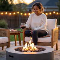 Brookhurst 43 In. W X 13 In. H round Outdoor GFRC Liquid Propane Fire Pit Table in Flint with Lava Rocks — Lifestyle